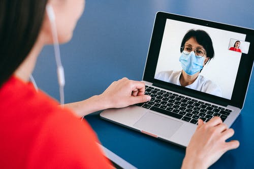 woman talking to doctor through video chat on laptop